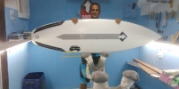 Na sala de shaper com uma prancha fabricada com a tecnologia Powerflex (Imagem: Arquivo Pessoal)