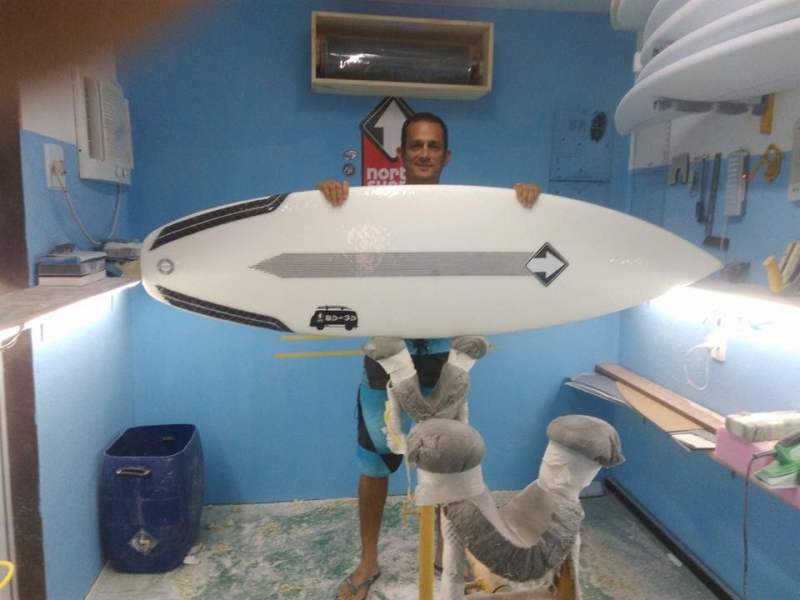 Na sala de shaper com uma prancha fabricada com a tecnologia Powerflex (Imagem: Arquivo Pessoal)