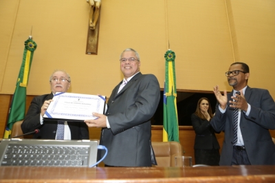 Luciano Bispo entrega a placa ao padre Inaldo (Foto: César de Oliveira)