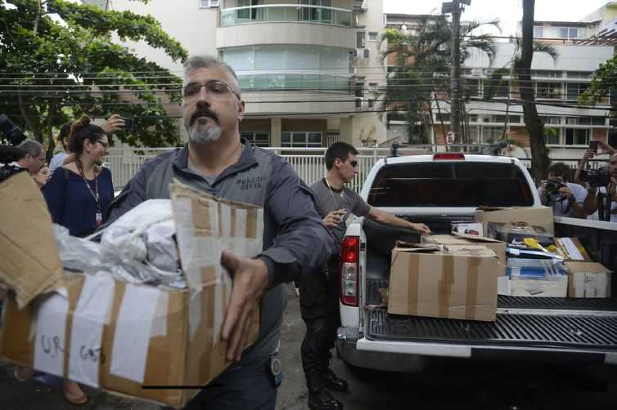 Policiais carregam caixas apreendidas em endereço ligado a suspeito de matar a vereadora Marielle Franco e o motorista Anderson Gomes (Foto: Tânia Rêgo/ Agência Brasil)