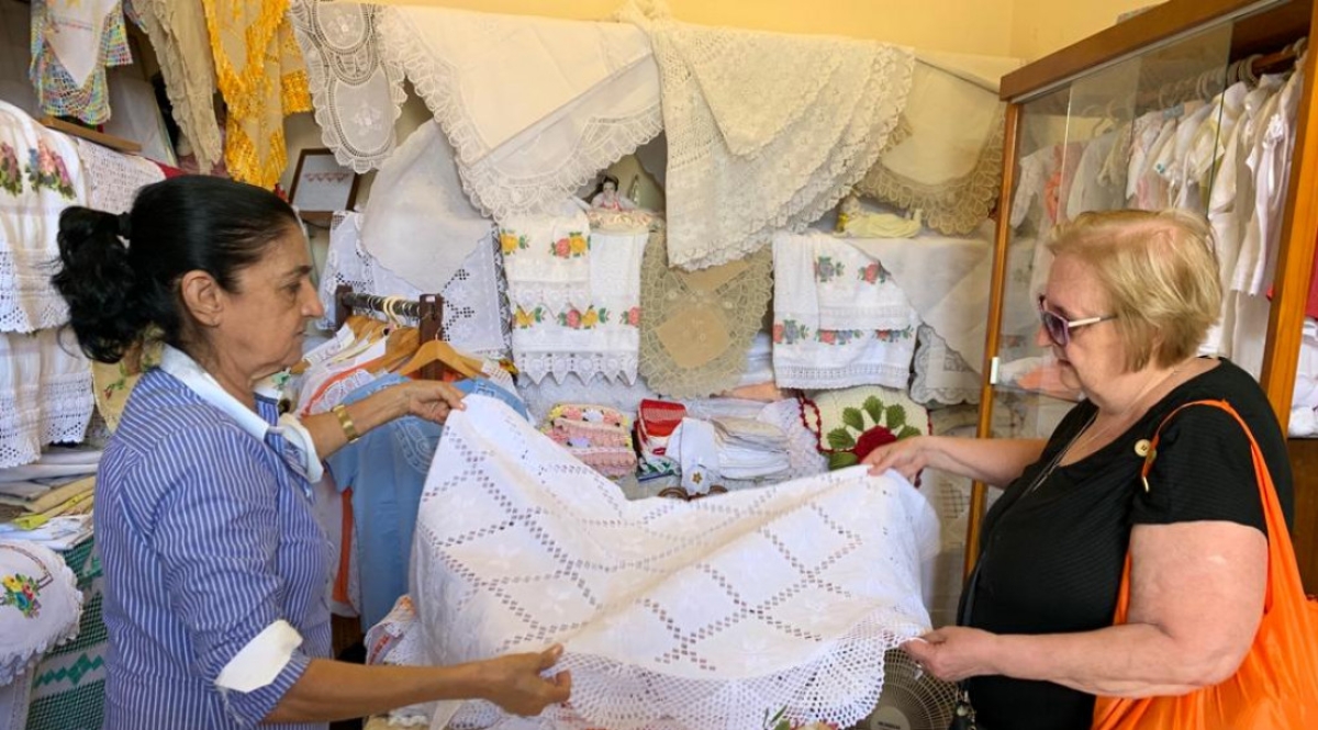 A professora aposentada Maria Teresa Mazali apreciando o artesanato sergipano - Foto: Max
Carlos | Governo de Sergipe