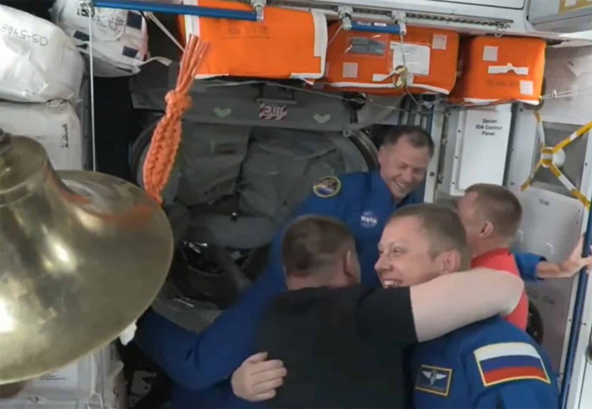 Nick Hague, astronauta da NASA, e Aleksandr Gorbunov, cosmonauta da agência espacial russa (Roscosmos), são recebidos pela tripulação a bordo da Estação Espacial Internacional - Foto: NASA TV

